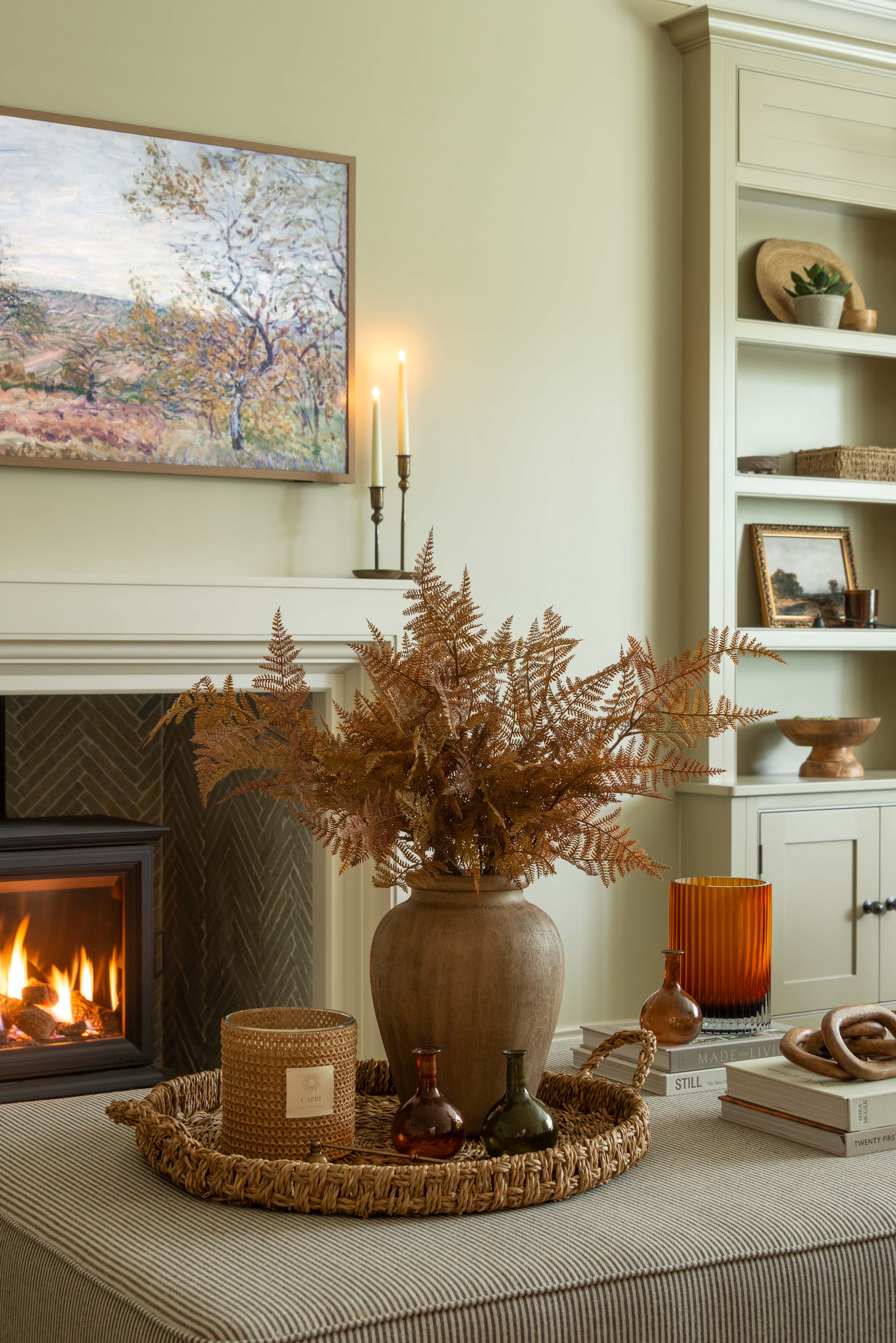 Brown faux fern stem styled in a rustic vase with warm autumn inspired decor