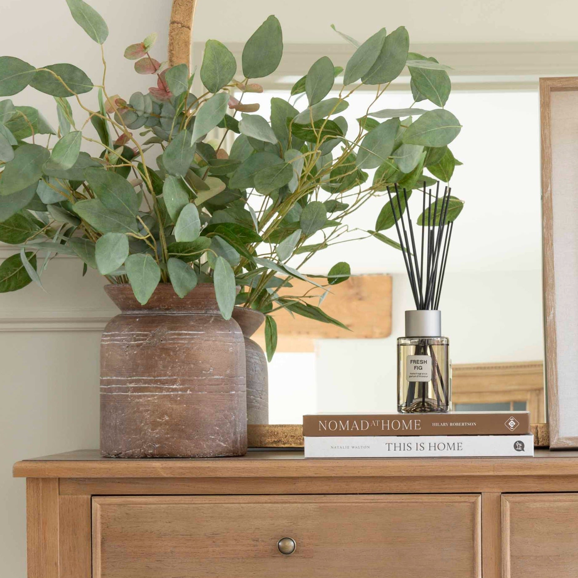 A fresh fig scented diffuser with reeds on a console