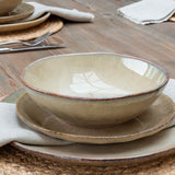 Glazed stoneware side plate with matching bowl and dinner plate on a rustic wooden table