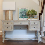 Vintage-inspired desk styled with books, flowers, and framed art