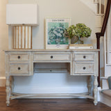 Vintage-inspired desk styled with books, flowers, and framed art