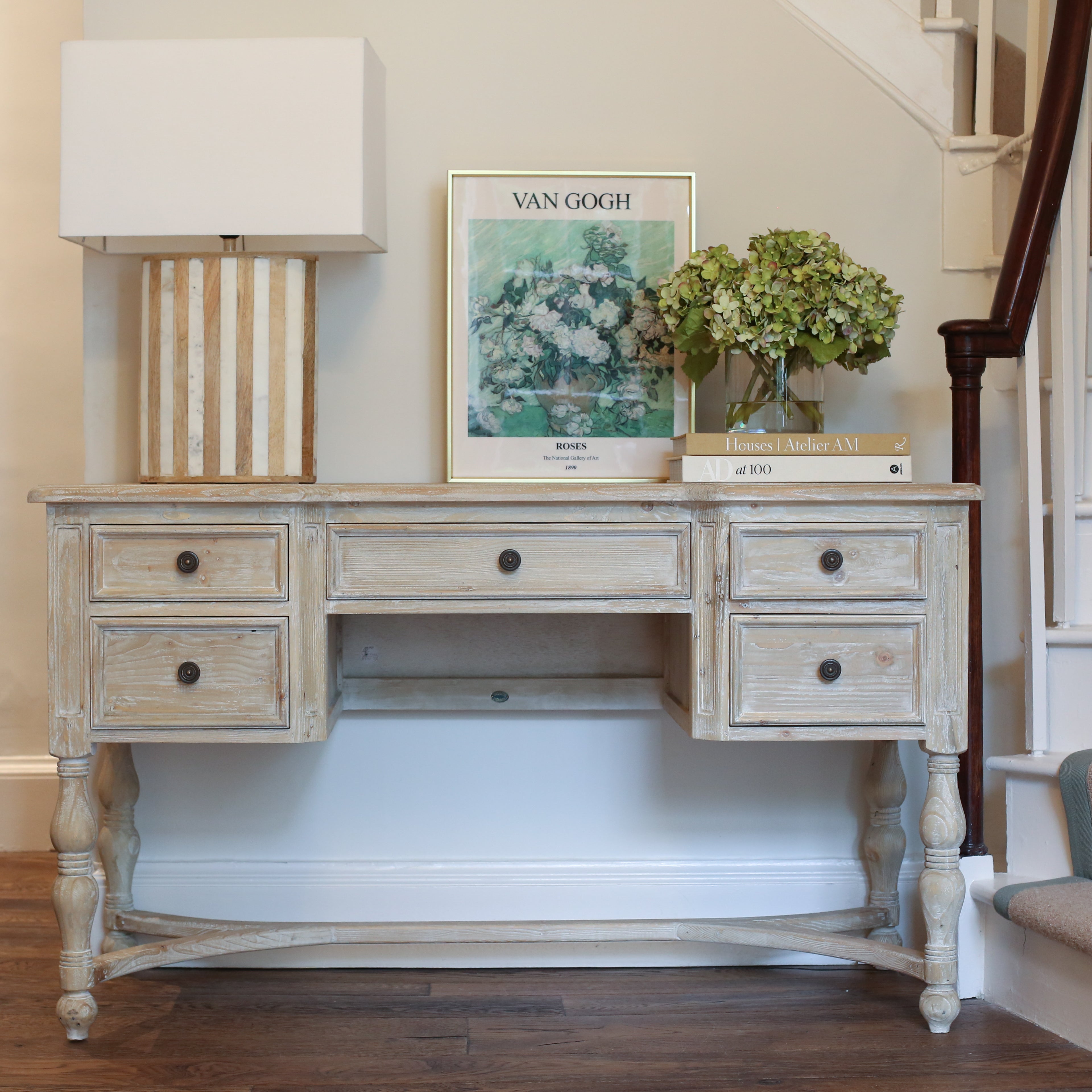 Vintage-inspired desk styled with books, flowers, and framed art
