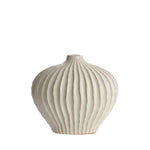 Ivory ribbed ceramic vase with rounded silhouette and modern textured design.