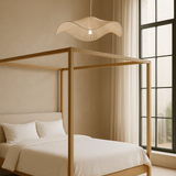 Wooden canopy bed in a bedroom with large windows and neutral decor.