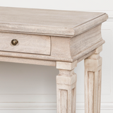 Wooden console table with a single drawer against a white wall