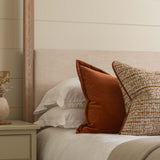 Bedroom with a bed featuring pillows and a wooden headboard against a shiplap wall.