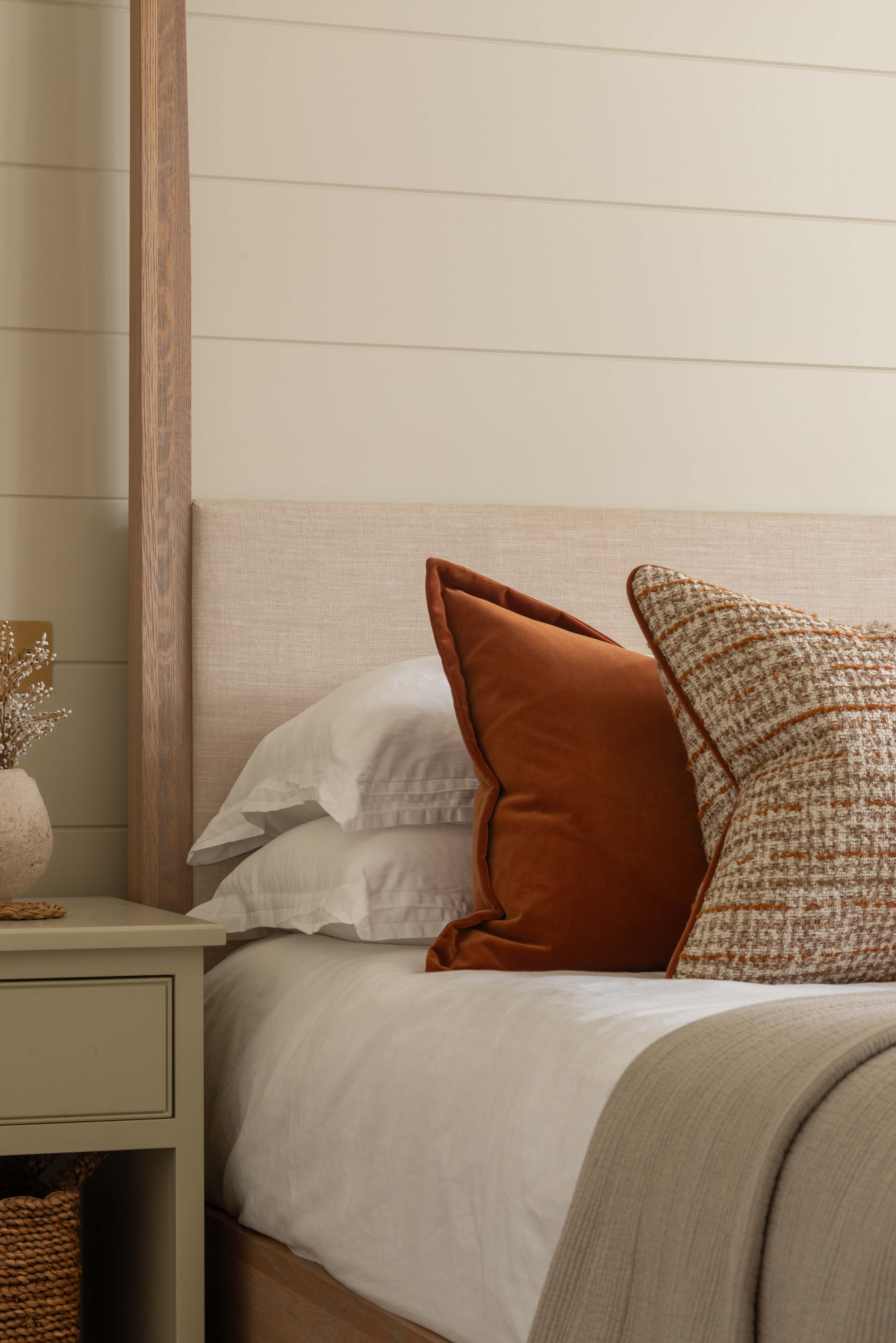 Bedroom with a bed featuring pillows and a wooden headboard against a shiplap wall.