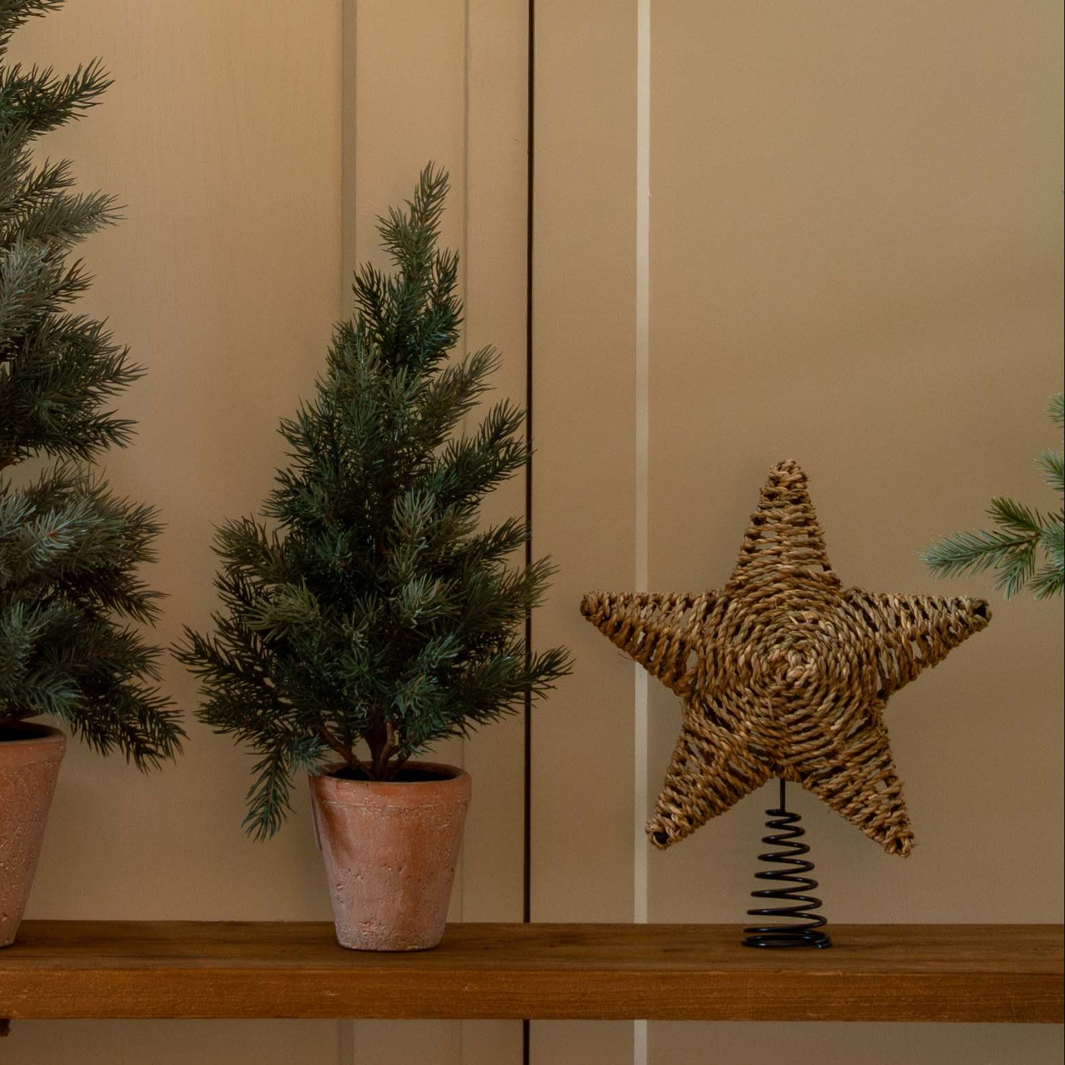 Decorative setup with Christmas trees, a star, and gift boxes in a home interior.