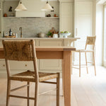 Kitchen with wooden table and chairs, light-colored cabinets, and a neutral color palette.