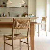Kitchen with wooden table and chairs, light-colored cabinets, and a tiled backsplash.