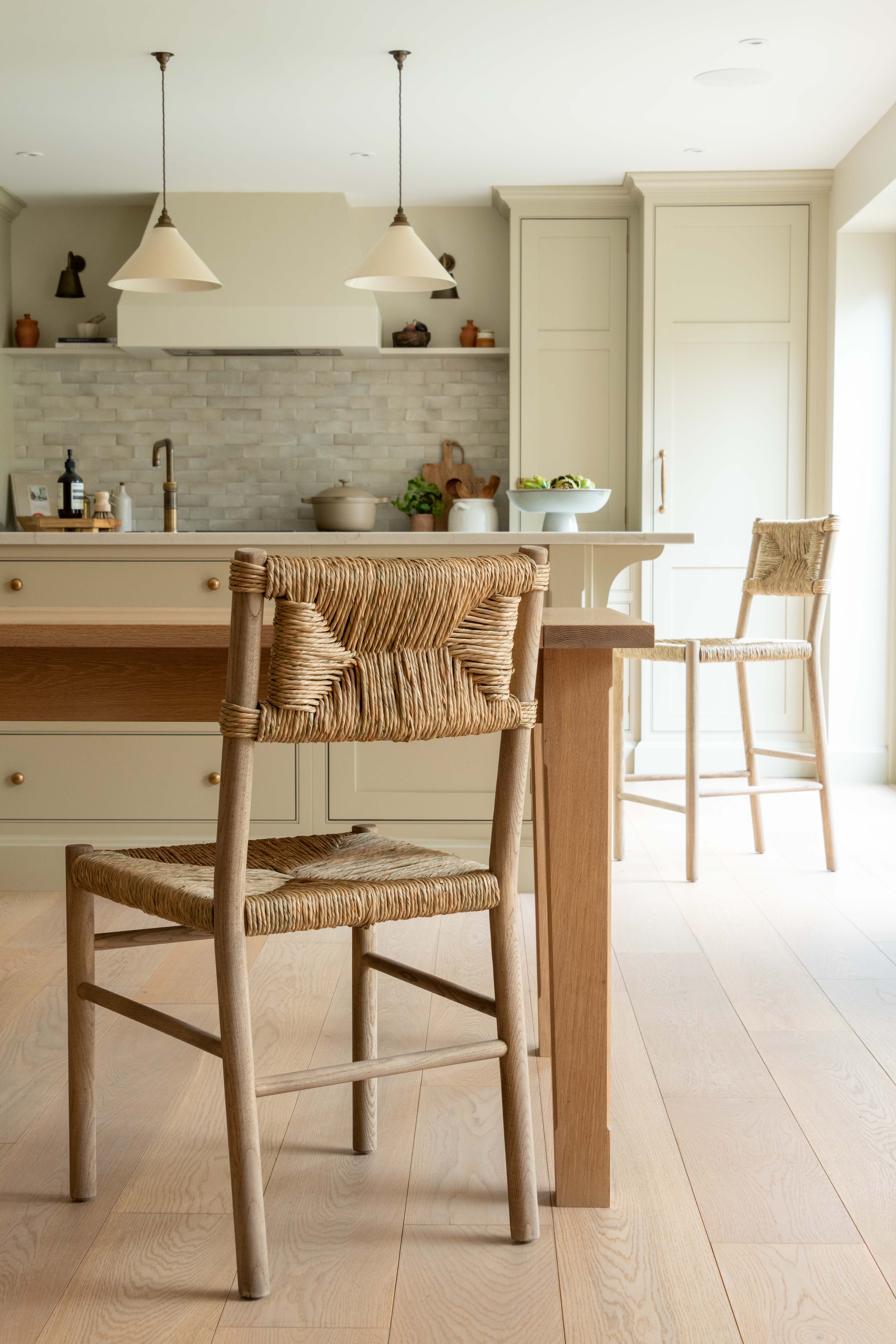 Kitchen with wooden table and chairs, light-colored cabinets, and a tiled backsplash.