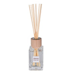 Reed diffuser with wooden sticks and clear bottle on a white background