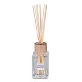 Reed diffuser with wooden sticks and clear bottle on a white background