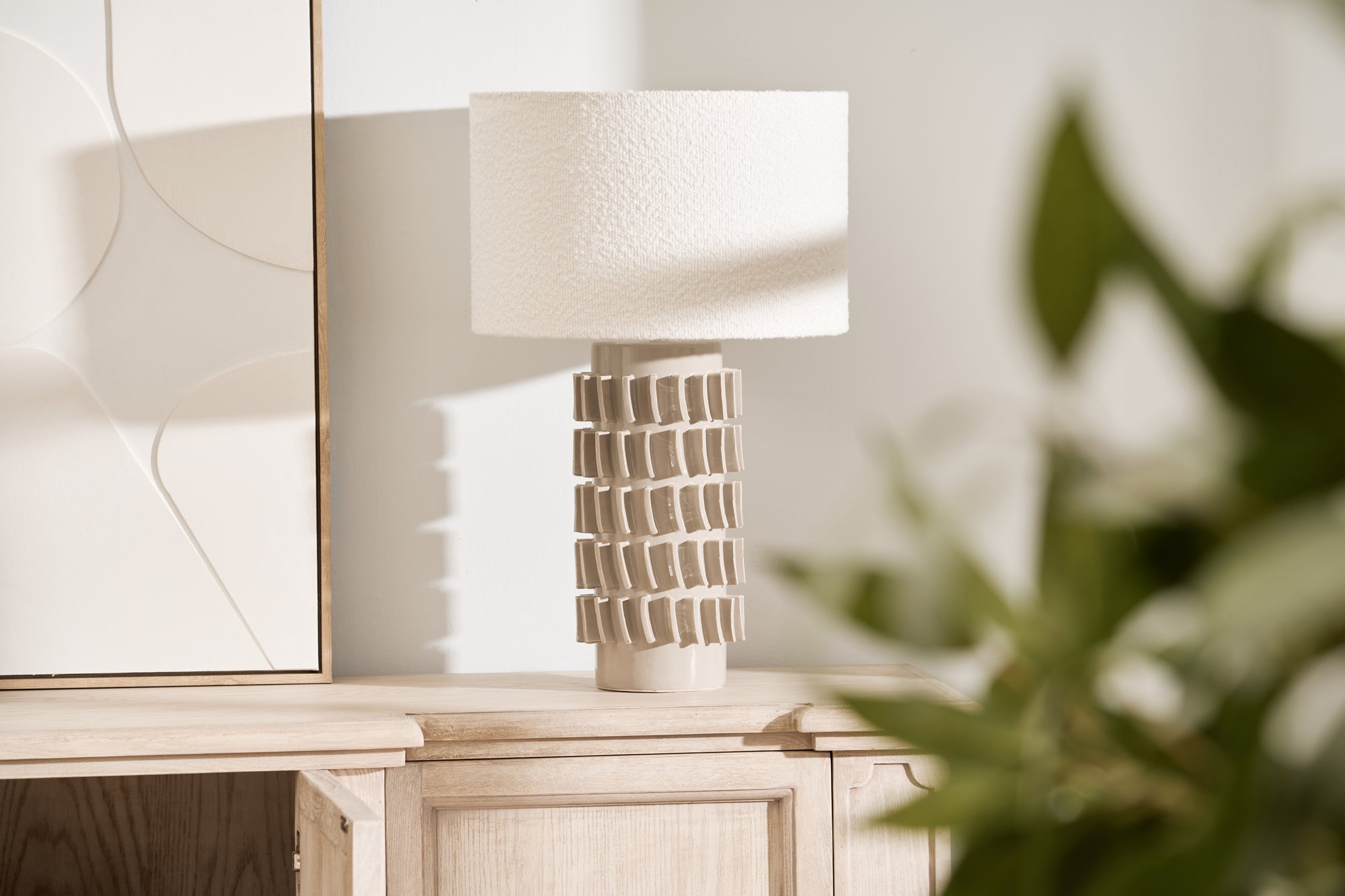 Samsara Bouclé Table Lamp styled on light wood console with modern artwork and décor