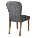 A stunning velvet chair in rich charcoal with brass stud detailing.