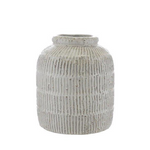 Crafted from terracotta, this vase features intricate ridged detailing and a distressed white glaze.