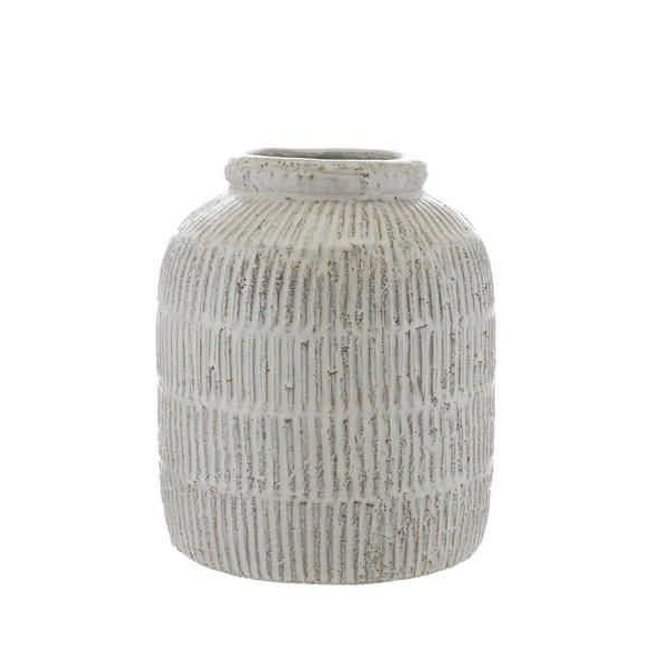 Crafted from terracotta, this vase features intricate ridged detailing and a distressed white glaze.