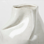 White ceramic vase with textured surface on a light gray background