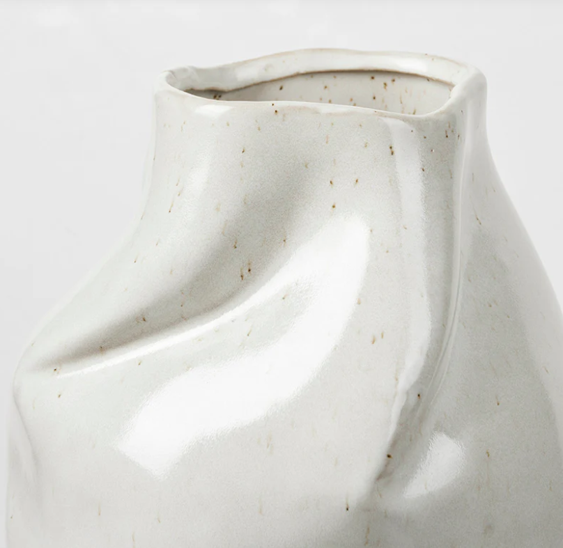 White ceramic vase with textured surface on a light gray background