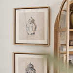 Two framed prints of chinoiserie urns hanging on a wall.