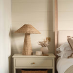Solara Rattan Table Lamp on bedside table with natural wicker coolie shade in cosy bedroom