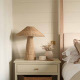 Solara Rattan Table Lamp on bedside table with natural wicker coolie shade in cosy bedroom