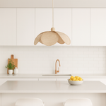 Modern kitchen with a rattan pendant light, white cabinets, and a bowl of lemons on the counter.