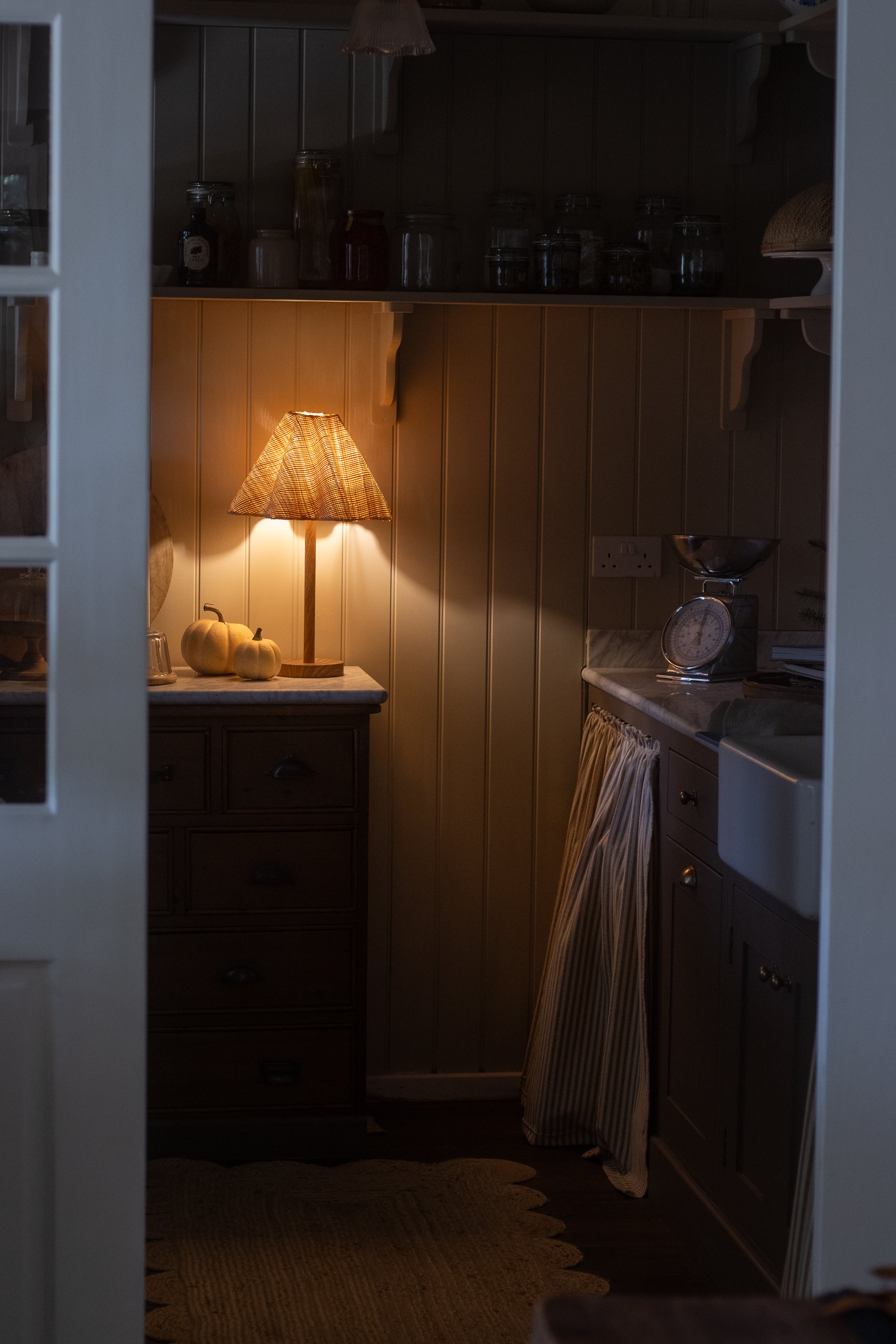 Soleil Rattan Lamp glowing warmly in a cozy rustic kitchen corner
