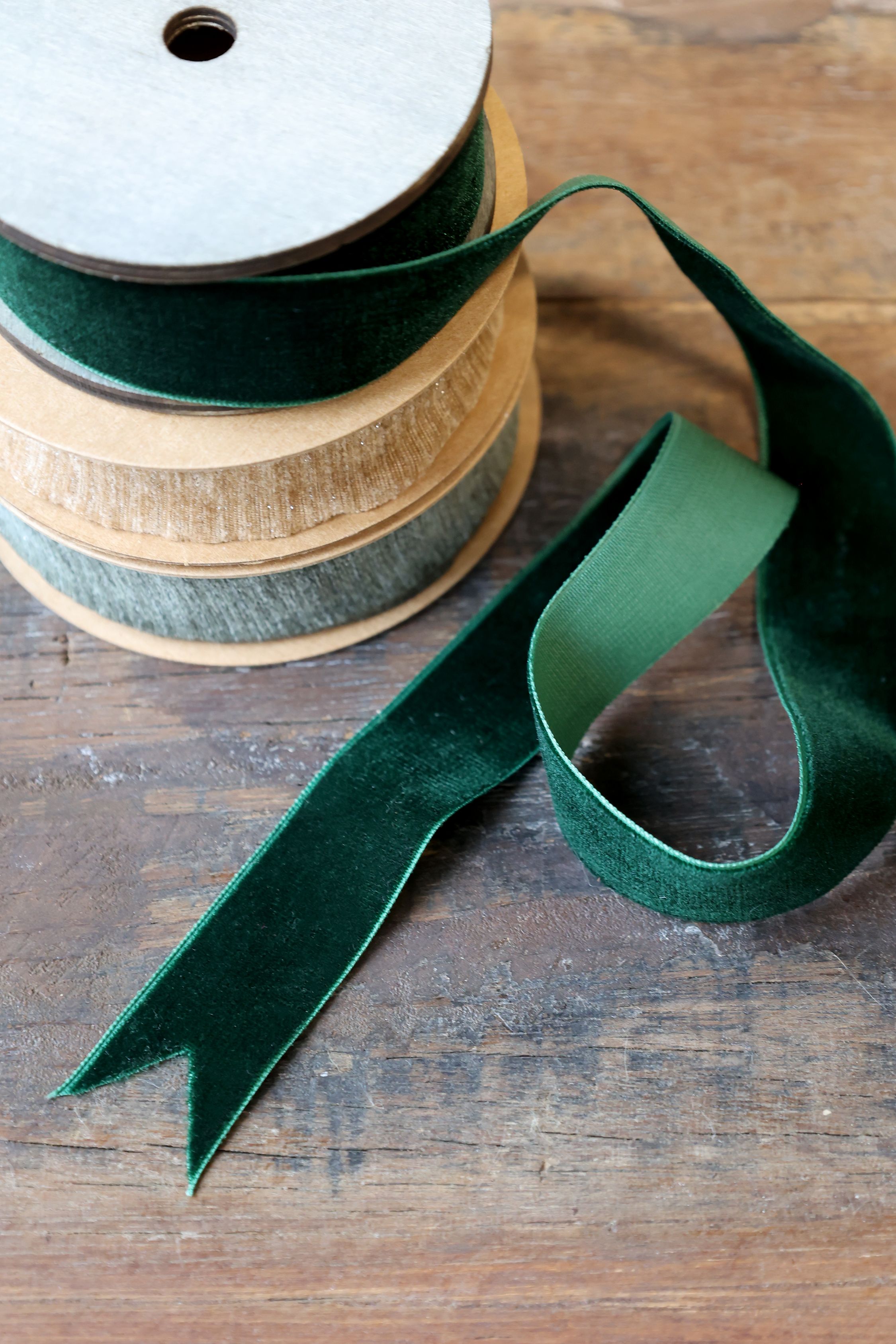 Spool of green ribbon on a wooden surface