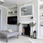 faux olive trees flanking a fireplace