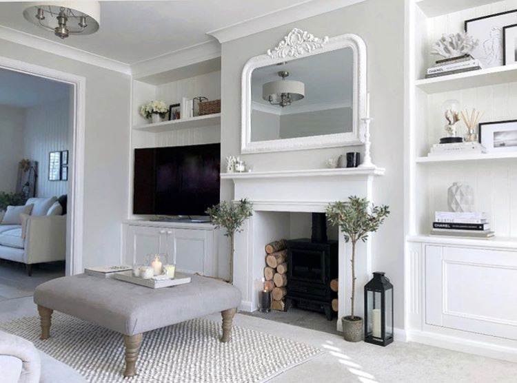 faux olive trees flanking a fireplace