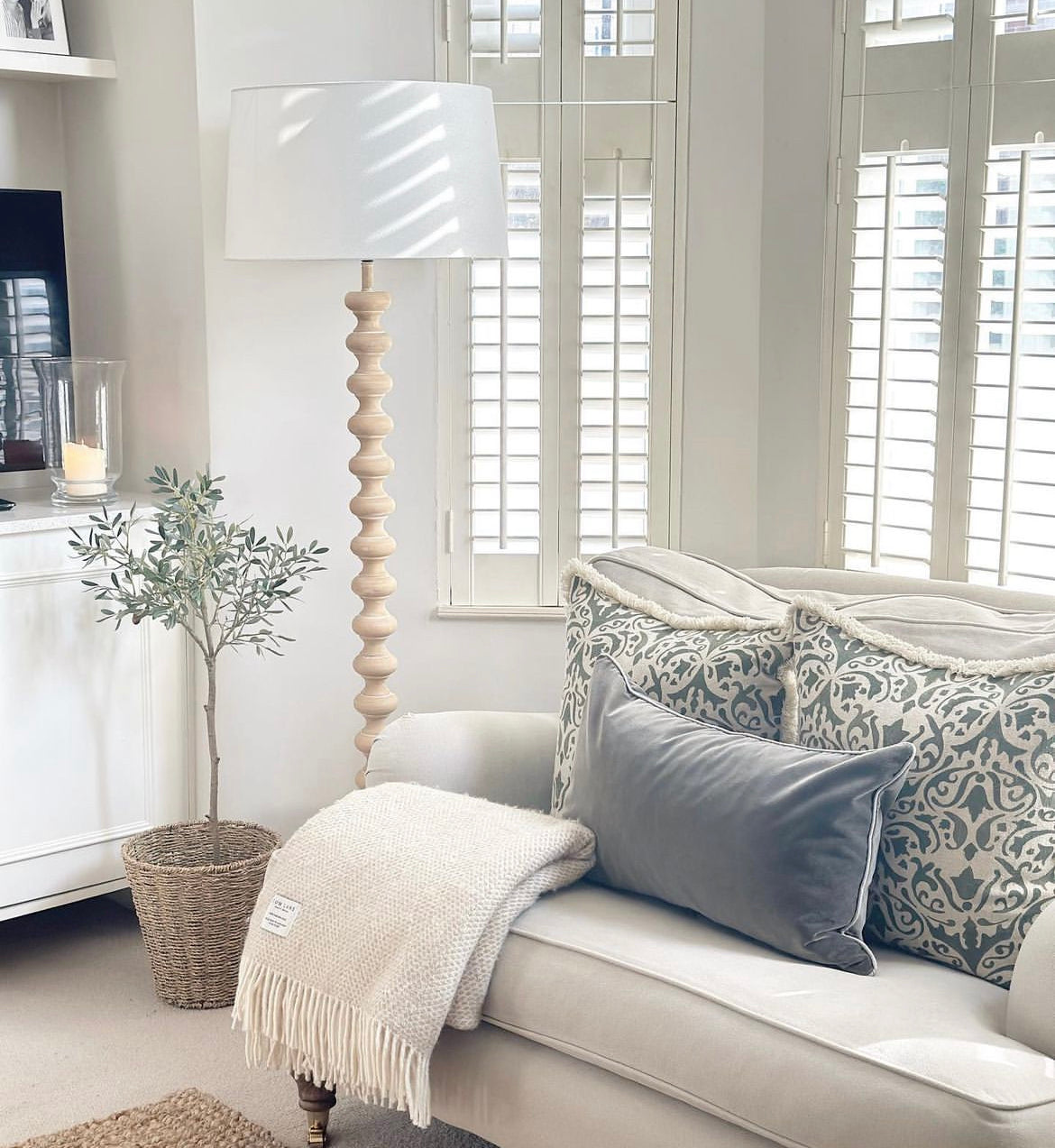 Georgia Floor Lamp styled in a bright living room beside sofa and window shutters