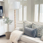Georgia Floor Lamp styled in a bright living room beside sofa and window shutters
