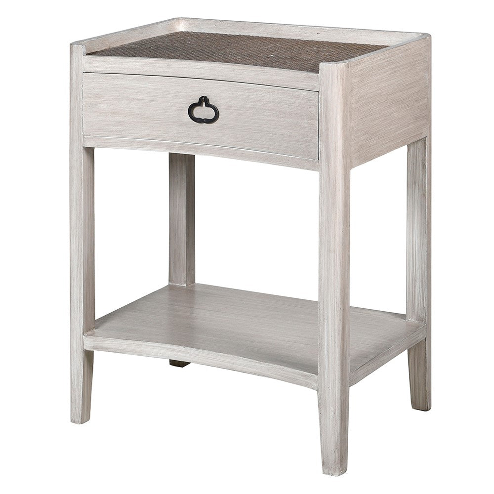 A white wash bedside table with rattan finish and a single drawer, alongside a lower shelf.