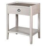 A white wash bedside table with rattan finish and a single drawer, alongside a lower shelf.