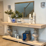 Large acacia wood console table supported by two balustrades