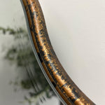 A beautiful frameless arched mirror.