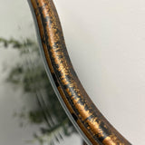 A beautiful frameless arched mirror.