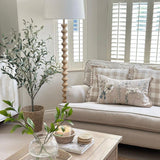 A stunning floor lamp in a beautiful turned pale wood complete with off white linen shade.