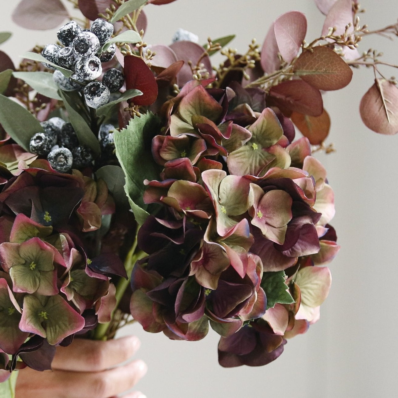 A stunningly lifelike faux burgundy hydrangea with a burgundy colour and hints of green.