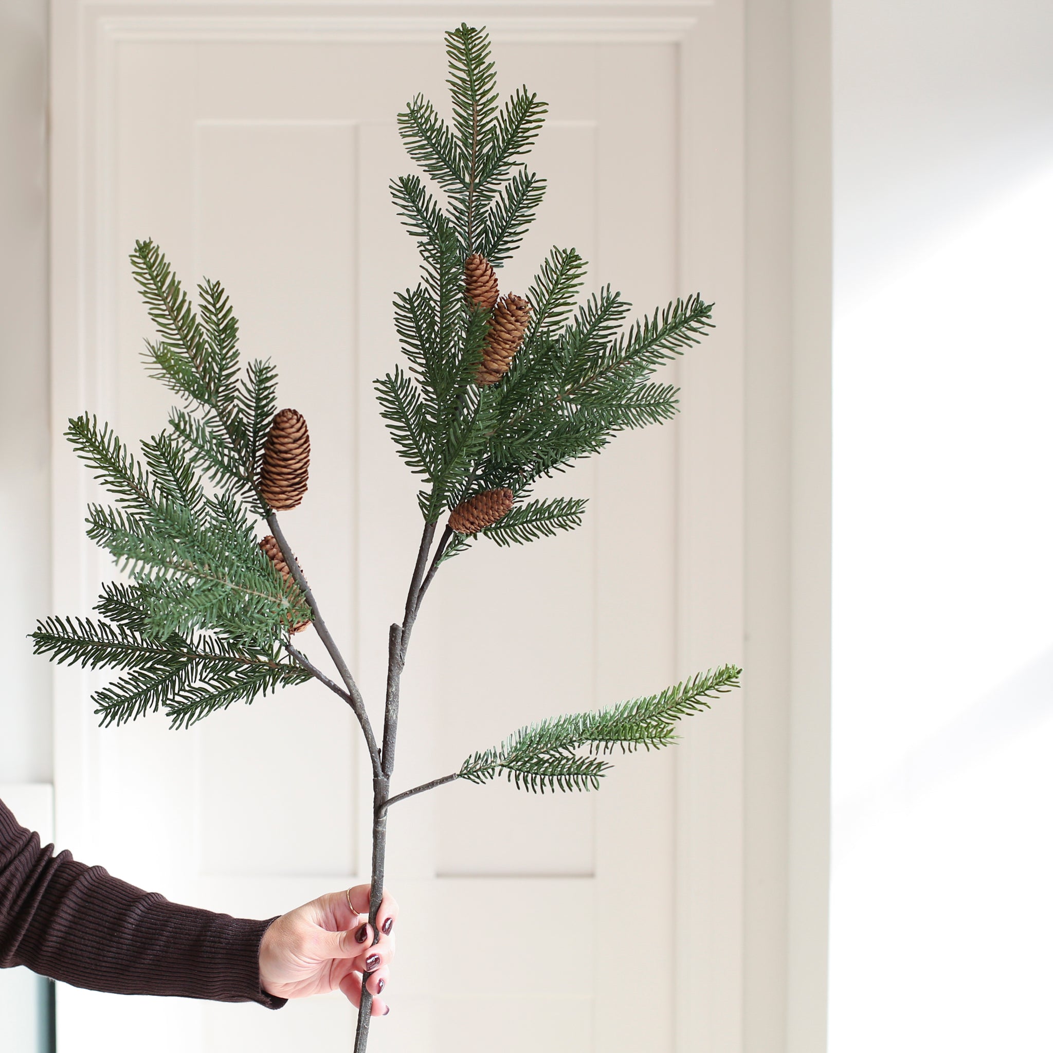 A lifelike stem of Spruce, complete with cones.