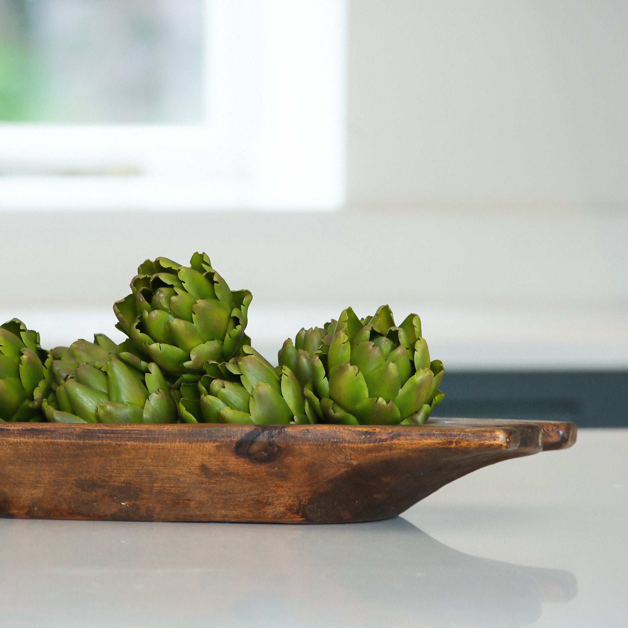 A set of three decorative faux green artichokes.