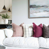 A stunning cotton cushion with a beautiful check detail arrayed on a white couch with other cushions