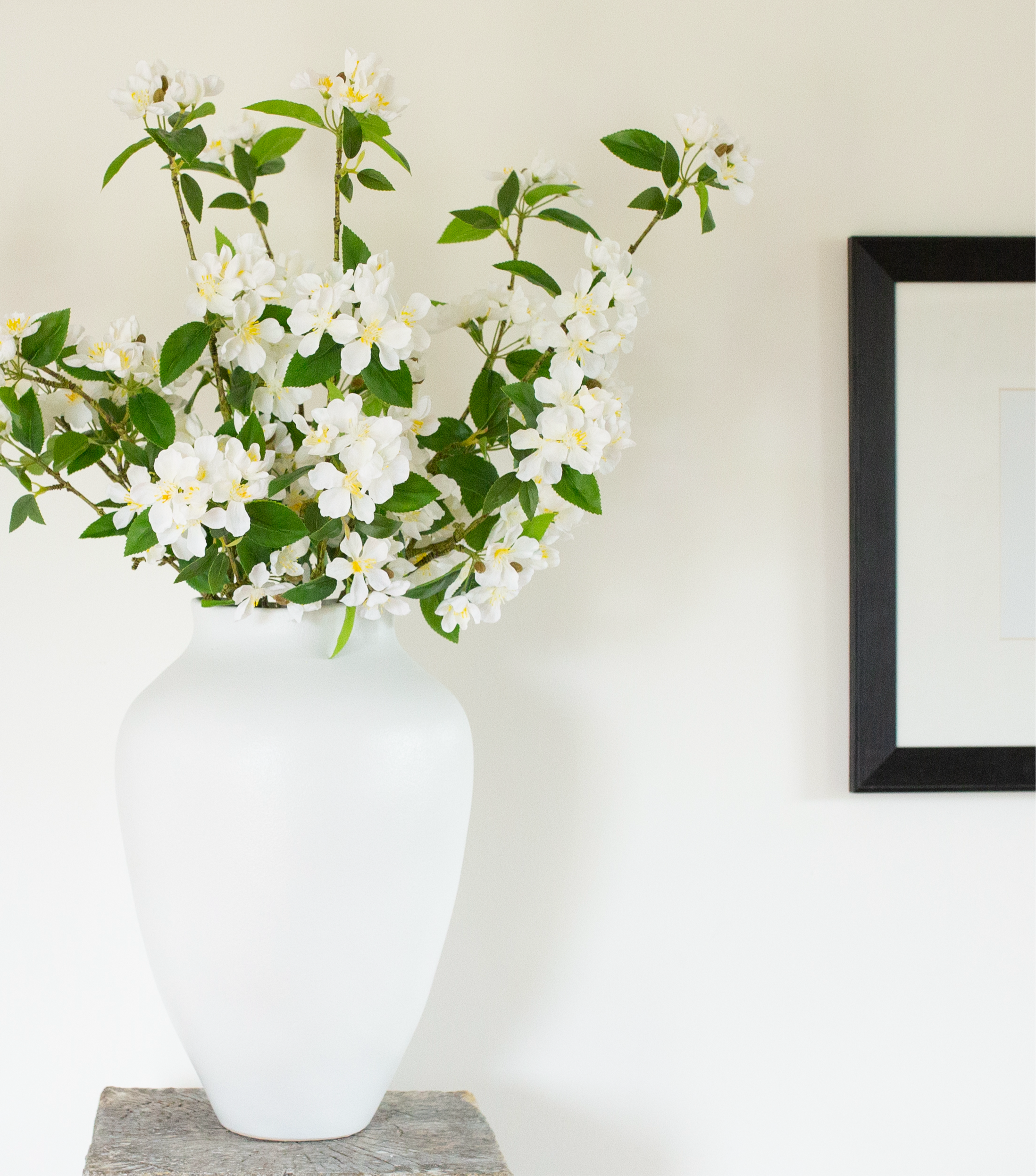 White cherry blossoms in a tall white vase