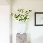 White cherry blossoms in a tall white vase