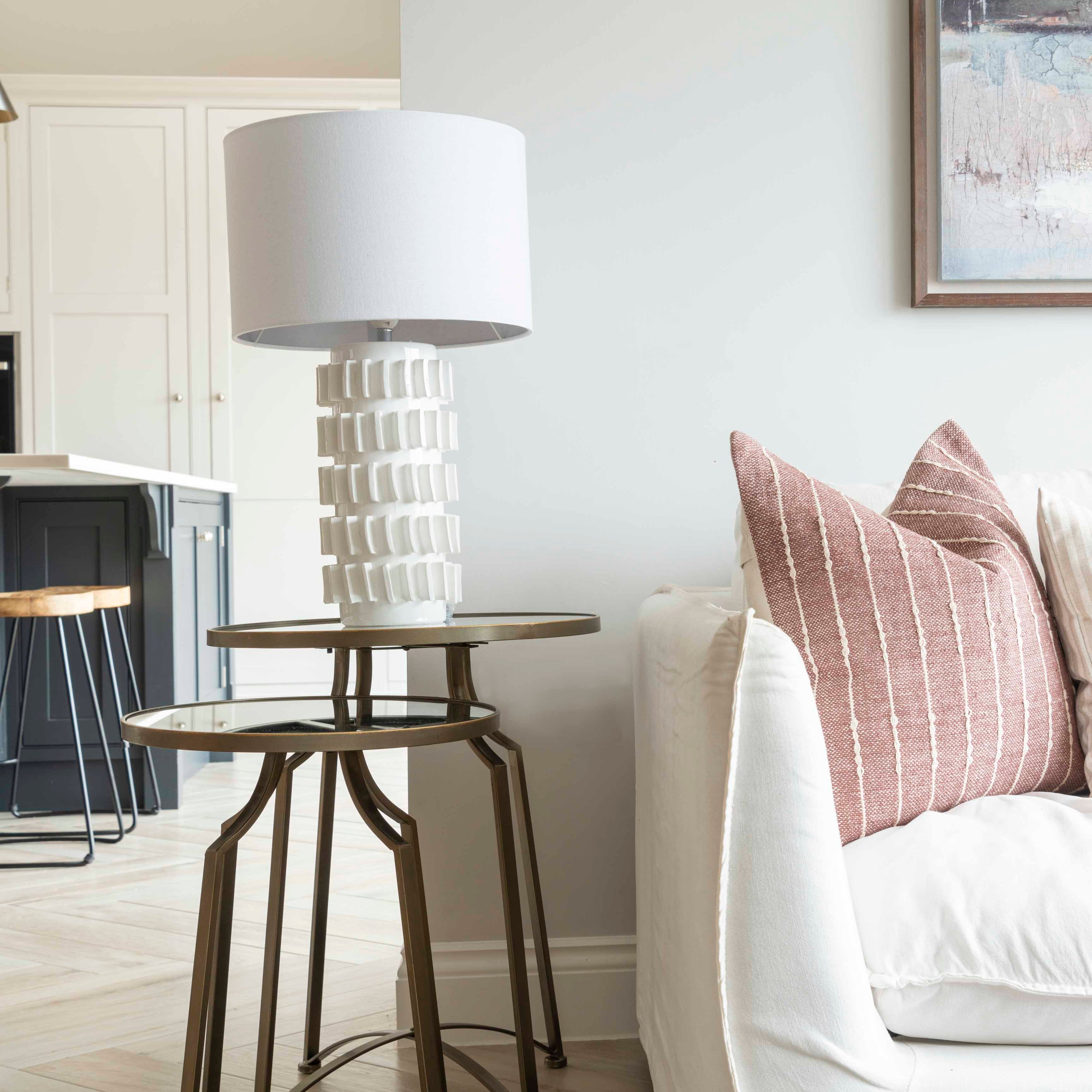 Crafted with white tiles that highlight its base, this lamp is finished with a sleek white shade.