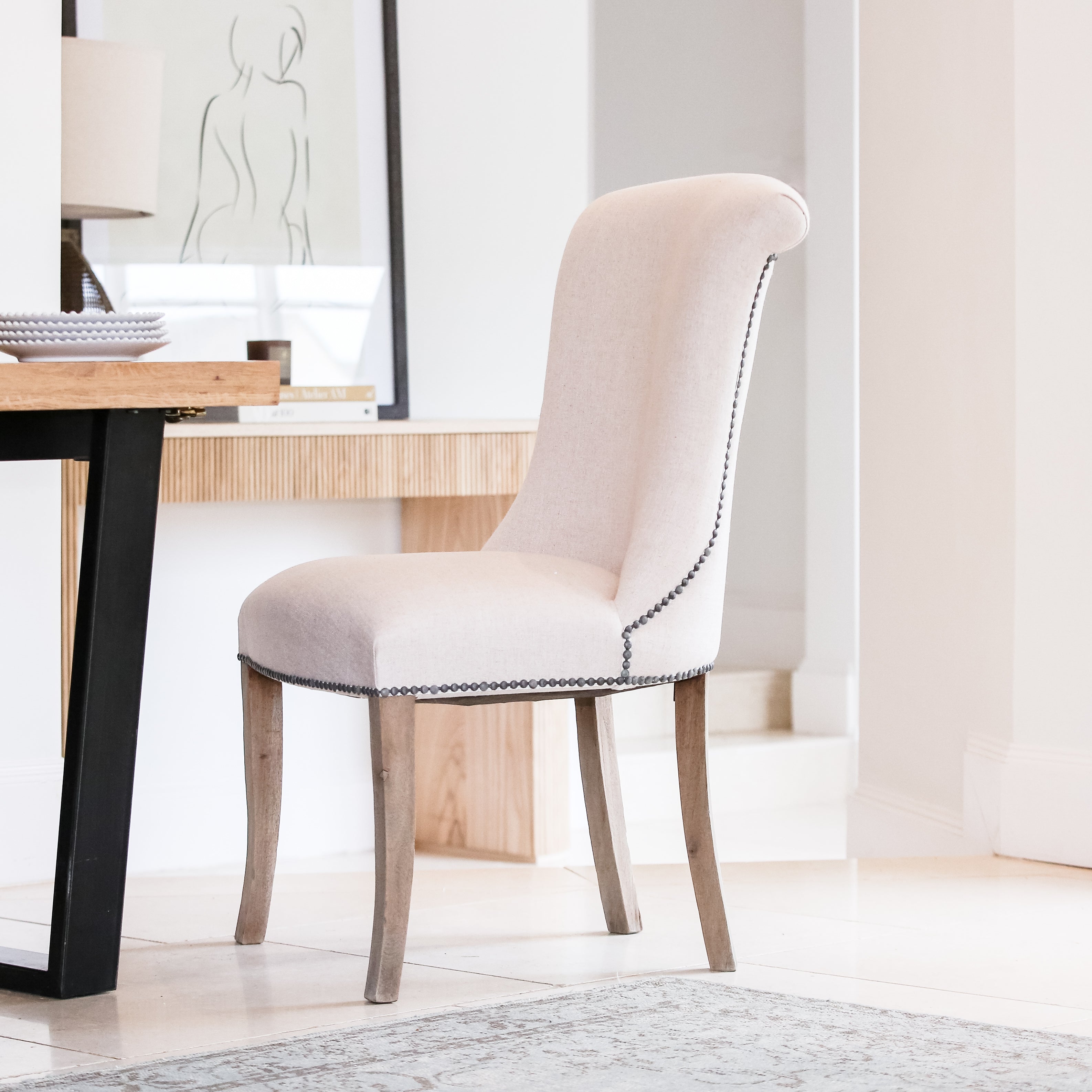 A striking dining chair in natural linen with stun detailing and ring back.