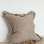 A beautiful linen cushion in taupe with white stripe running through and ruffled edges