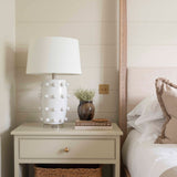  Crafted from sleek white ceramic and adorned with elegant bobble detailing, this lamp comes complete with a crisp white shade. 