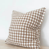 Cushion with a brown checker pattern and frayed edges